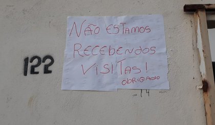 Mulher coloca cartaz na porta de casa para proteger marido do novo coronavírus. (Foto: Tatiane Viana/Arquivo pessoal)