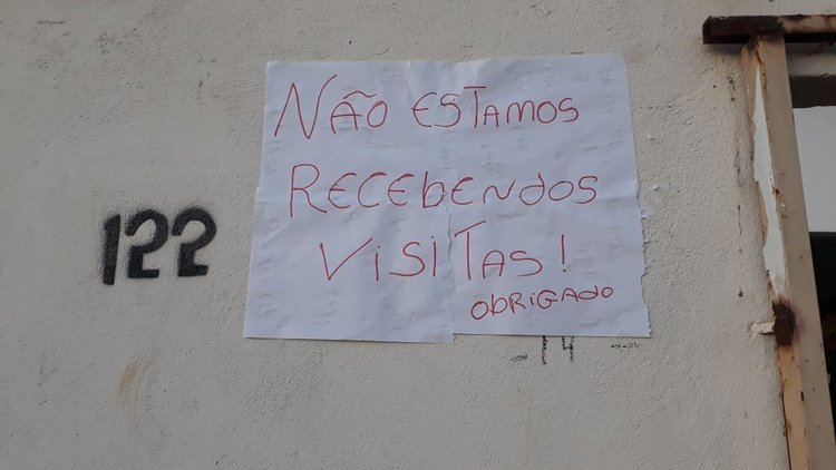Mulher coloca cartaz na porta de casa para proteger marido do novo coronavírus.