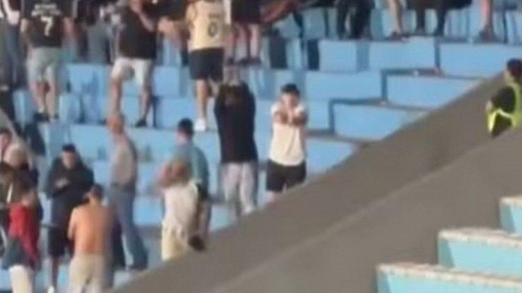 Torcedor do Botafogo fazendo sinal de mãos algemadas em jogo no Uruguai