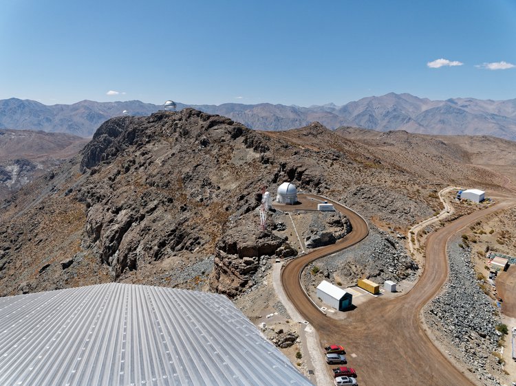 Vista do alto da cúpula do Observatório Rubin em direção aos telescópios vizinhos em Cerro Pachón, nas montanhas do deserto chileno.