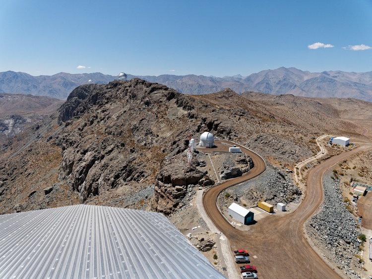 Vista do alto da cúpula do Observatório Rubin em direção aos telescópios vizinhos em Cerro Pachón, nas montanhas do deserto chileno.