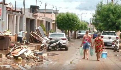 Moradores distribuem água potável para vizinhos que tiveram casas invadidas após chuva em Picos, no Piauí (Foto: Reprodução)