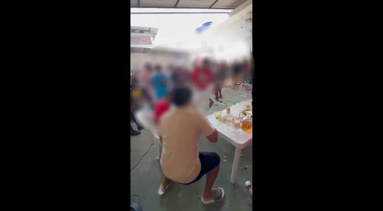 Em festa clandestina, detentos dançam e consomem bebida alcoólica.