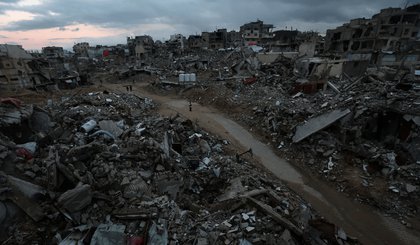 Palestinos caminham entre os escombros de edifícios destruídos em Khan Younis, no sul de Gaza, em 24 de fevereiro de 2025• Ramadan Abed / Reuters (Foto: • Ramadan Abed / Reuters)