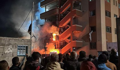 Palestinos observam operação de combate a incêndio após bombardeio no Hospital Nasser, em Khan Younis (Foto: AFP)
