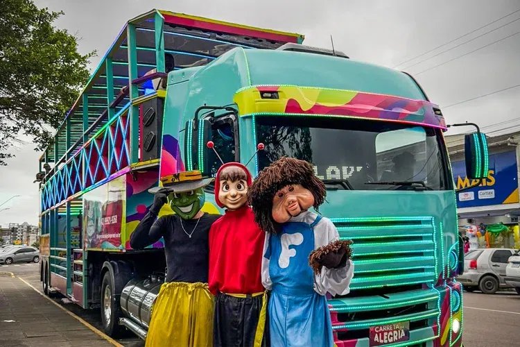Carreta da Alegria: personagems posam em frente de ônibus de dois andares