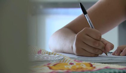 Adolescente escreve em caderno (Foto: Reprodução/EPTV)