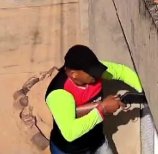 Imagens mostram o suspeito, portando uma espingarda calibre .12, tentando forçar o portão da casa.
